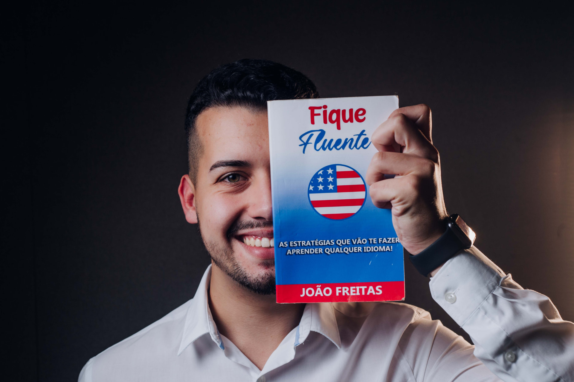 João Freitas segurando seu livro Fique Fluente